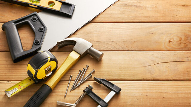 variety of carpentry tools on wood planks with copy space